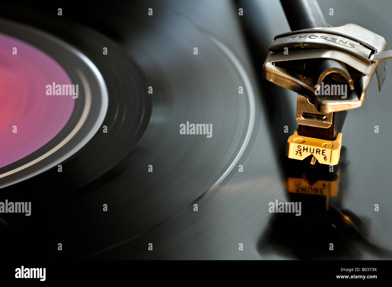 Testa di lettura Shure, posizionata su un disco in vinile nero, che ruota su un lettore di dischi. Foto Stock