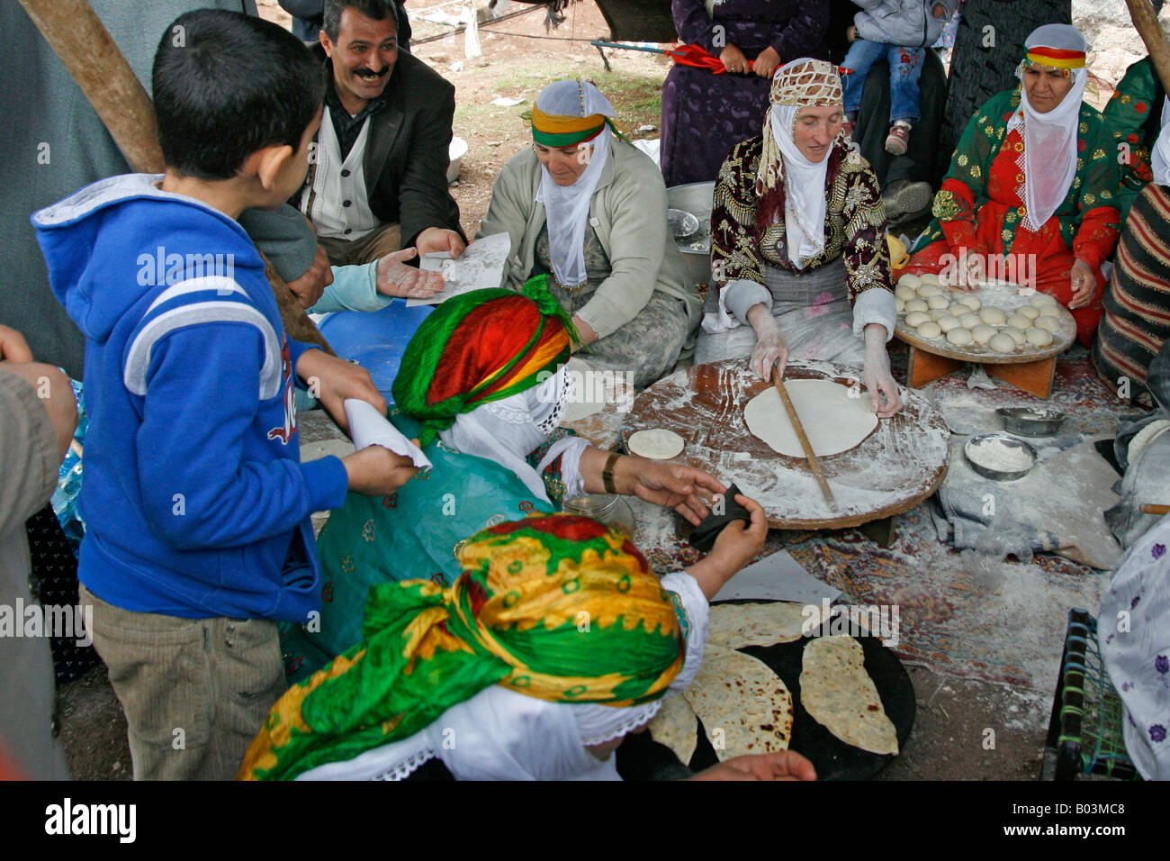 Donne curde impastare e cuocere gözleme crepes in uno degli alimenti tende all'annuale Newroz rally Diyarbakir Foto Stock