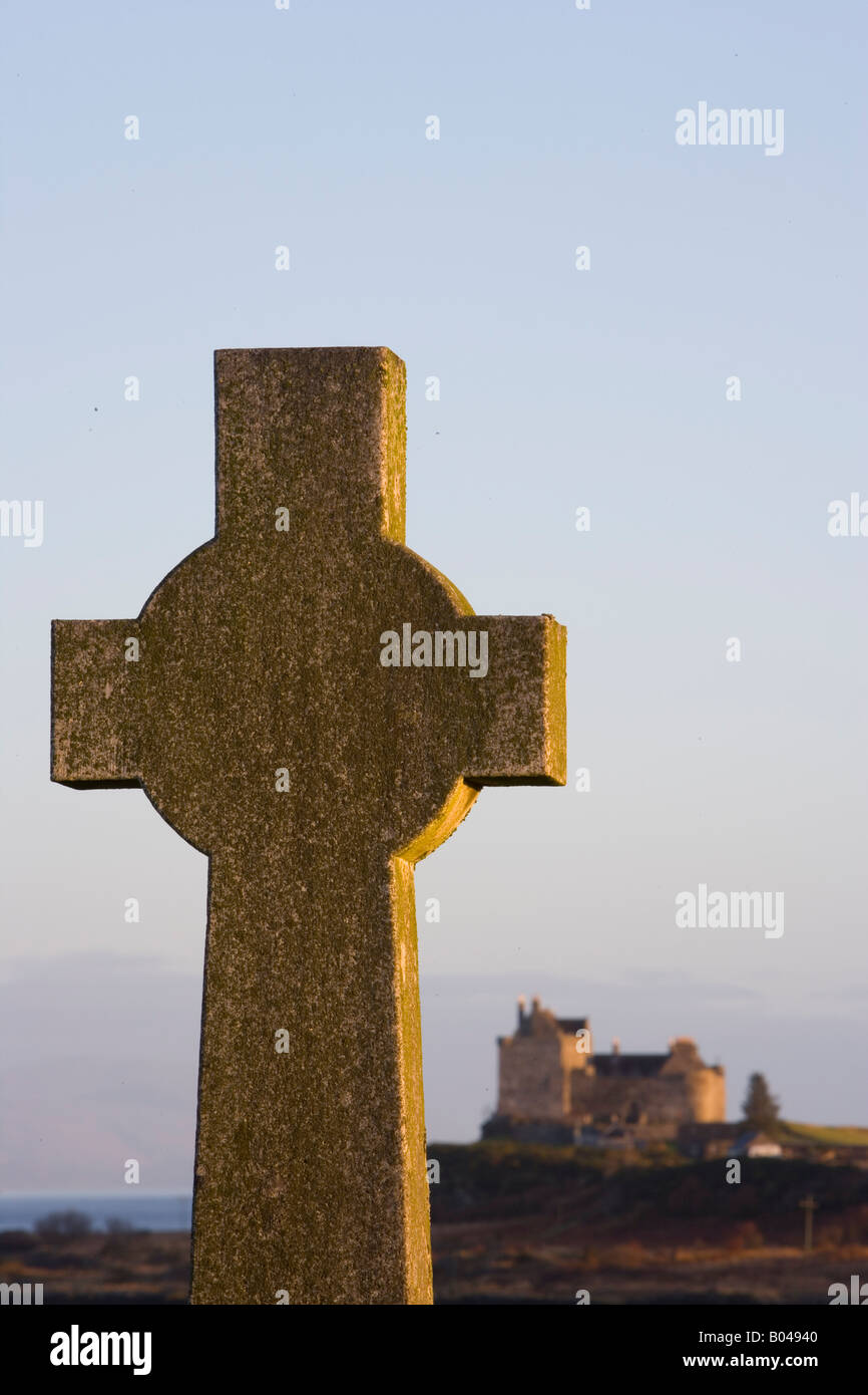 Croce celtica nel cimitero, con il Castello di Duart dietro, Isle of Mull, Scozia Foto Stock