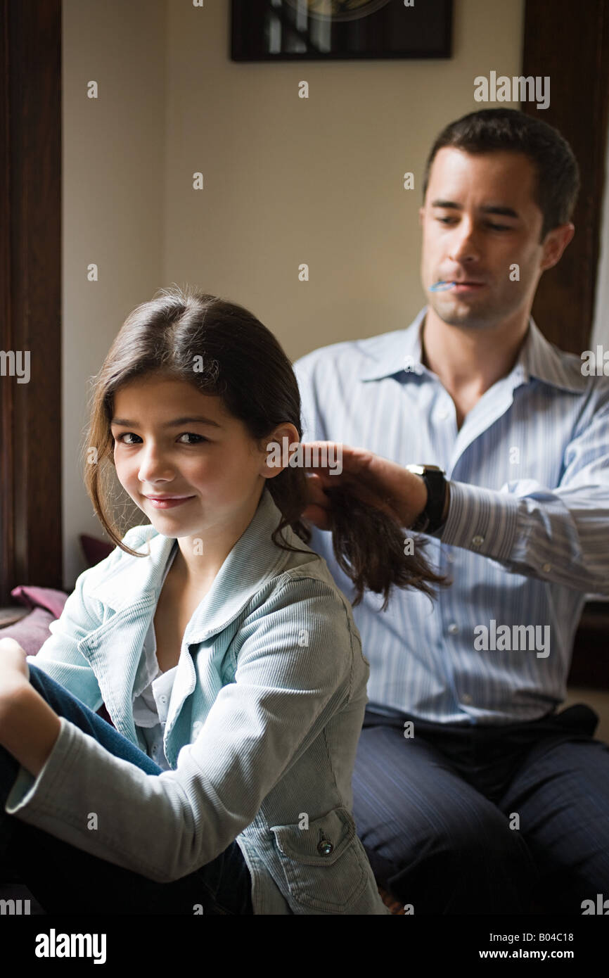 Un padre lo styling delle sue figlie capelli Foto Stock