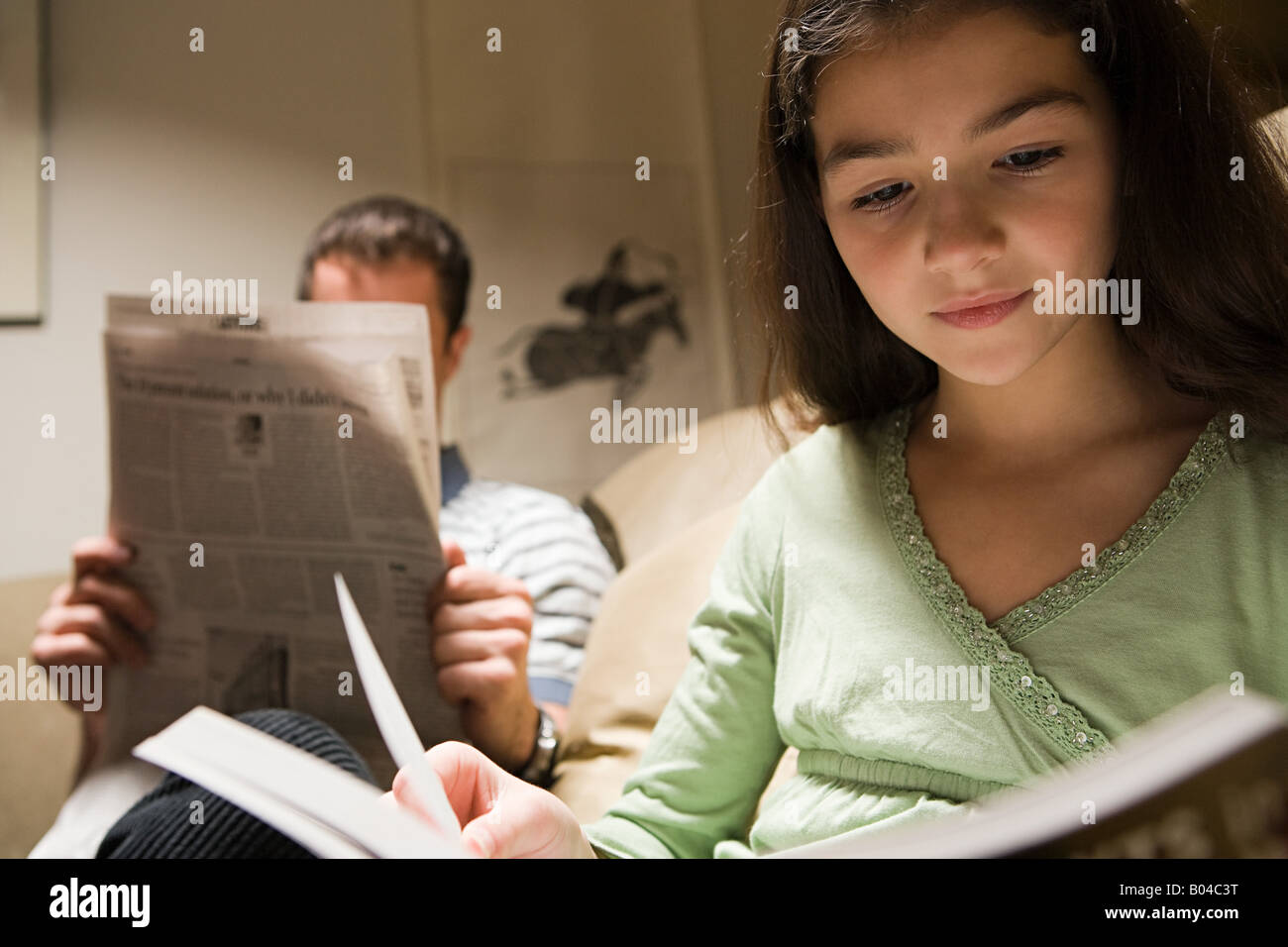 Un padre e figlia la lettura nella lounge Foto Stock