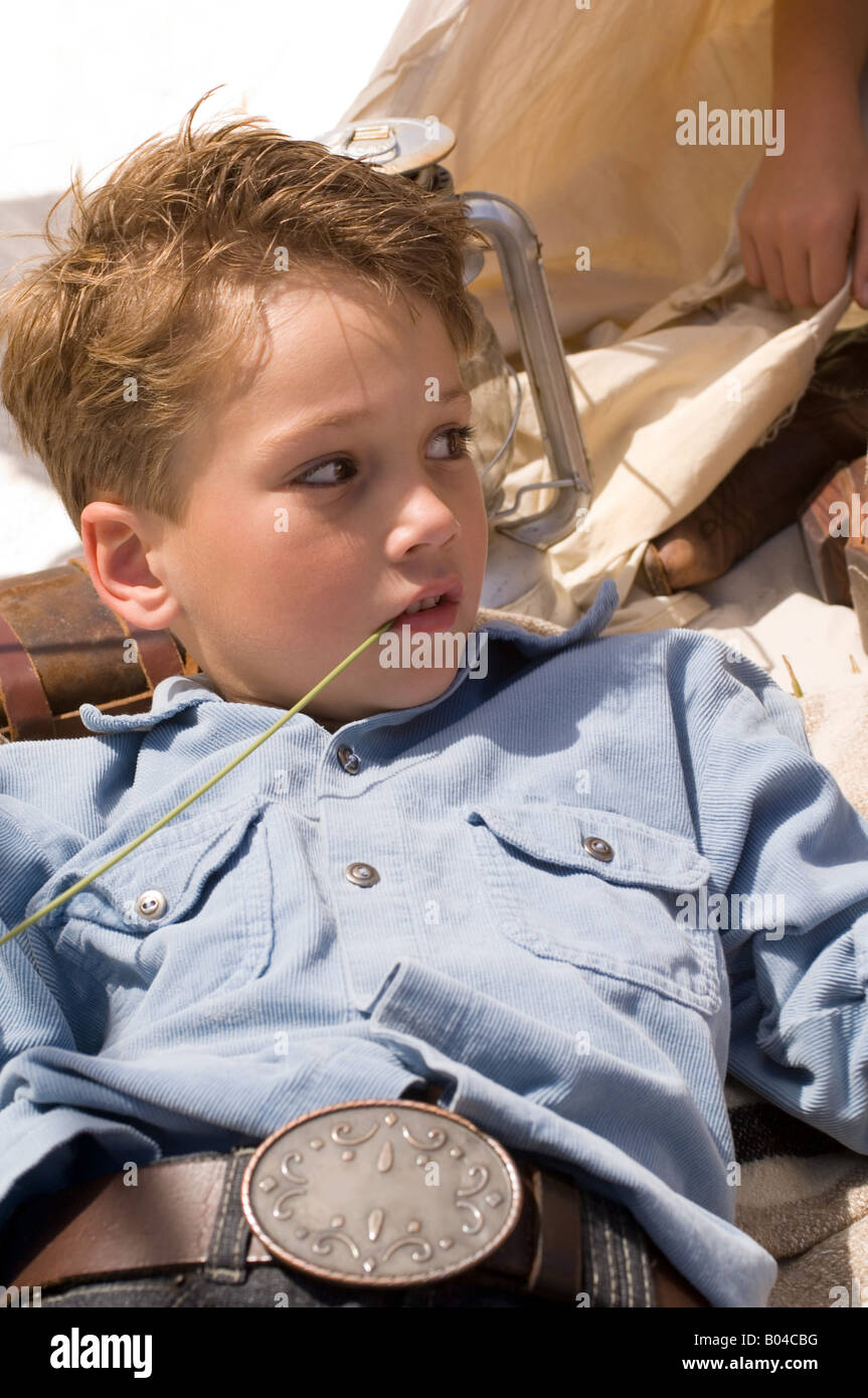 Un ragazzo masticare sull'erba Foto Stock