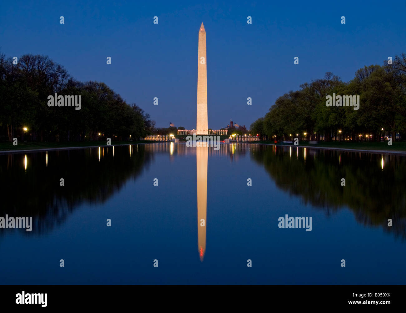 Washington Monument Reflection Reflection Pool Washington DC // WASHINGTON DC - il Washington Monument si erge illuminato contro il cielo notturno con il suo perfetto riflesso catturato nelle acque tranquille del Lincoln Memorial Reflecting Pool. L'obelisco in marmo di 555 piedi (169 metri) onora il primo presidente americano e rimane uno dei monumenti più riconoscibili del National Mall. Completato nel 1884, il monumento attrae circa 25.000 visitatori al giorno che possono salire sulla sua piattaforma di osservazione per ammirare vedute panoramiche della capitale. La piscina riflettente, che si estende per 2.029 piedi (618 metri) Foto Stock