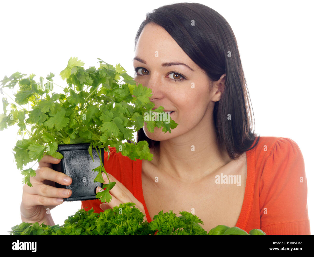 Giovane donna con una piscina Homegrown fresco giardino di erbe isolata contro uno sfondo bianco con un tracciato di ritaglio Foto Stock