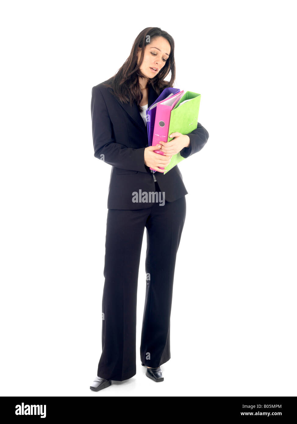 Giovane donna di affari o lavoratore di ufficio che porta una pila di cartelle isolata contro uno sfondo bianco con un tracciato di ritaglio Foto Stock
