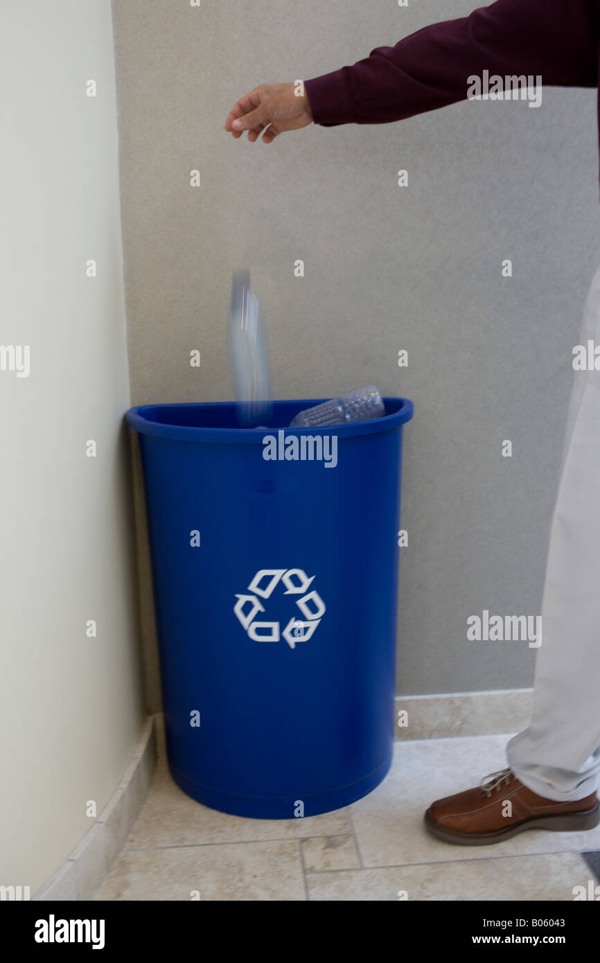 Ufficio dipendente scende bottiglia d'acqua in plastica nel contenitore di riciclaggio Foto Stock