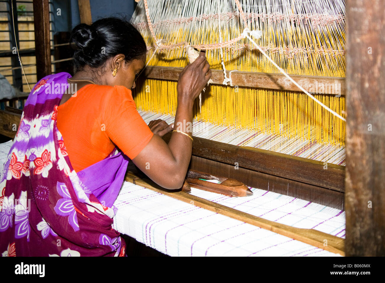 Donna che lavorano in corrispondenza di un telaio tessile in una fabbrica di tessitura, Madurai, Tamil Nadu, India Foto Stock