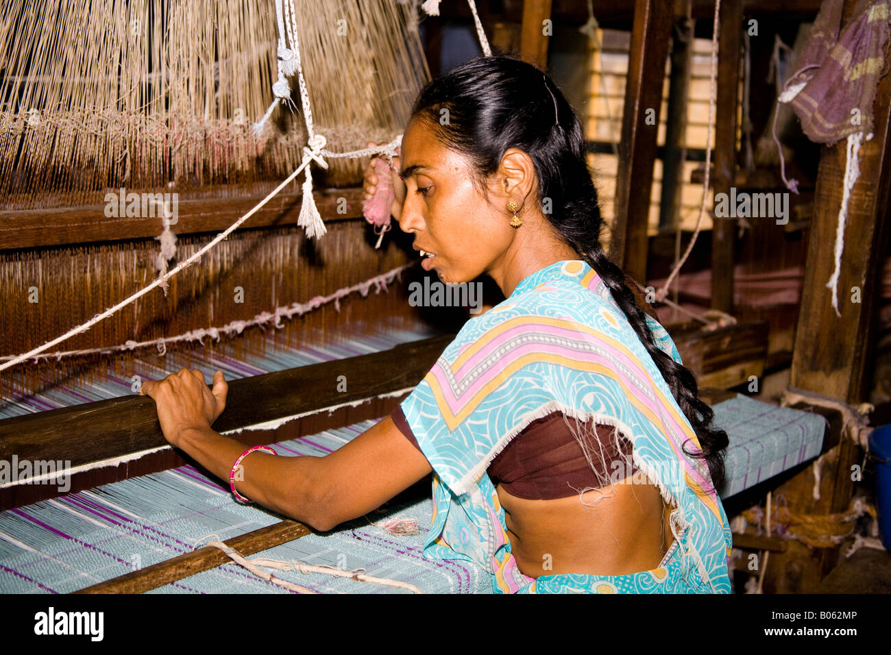 Donna che lavorano in corrispondenza di un telaio tessile in una fabbrica di tessitura, Madurai, Tamil Nadu, India Foto Stock