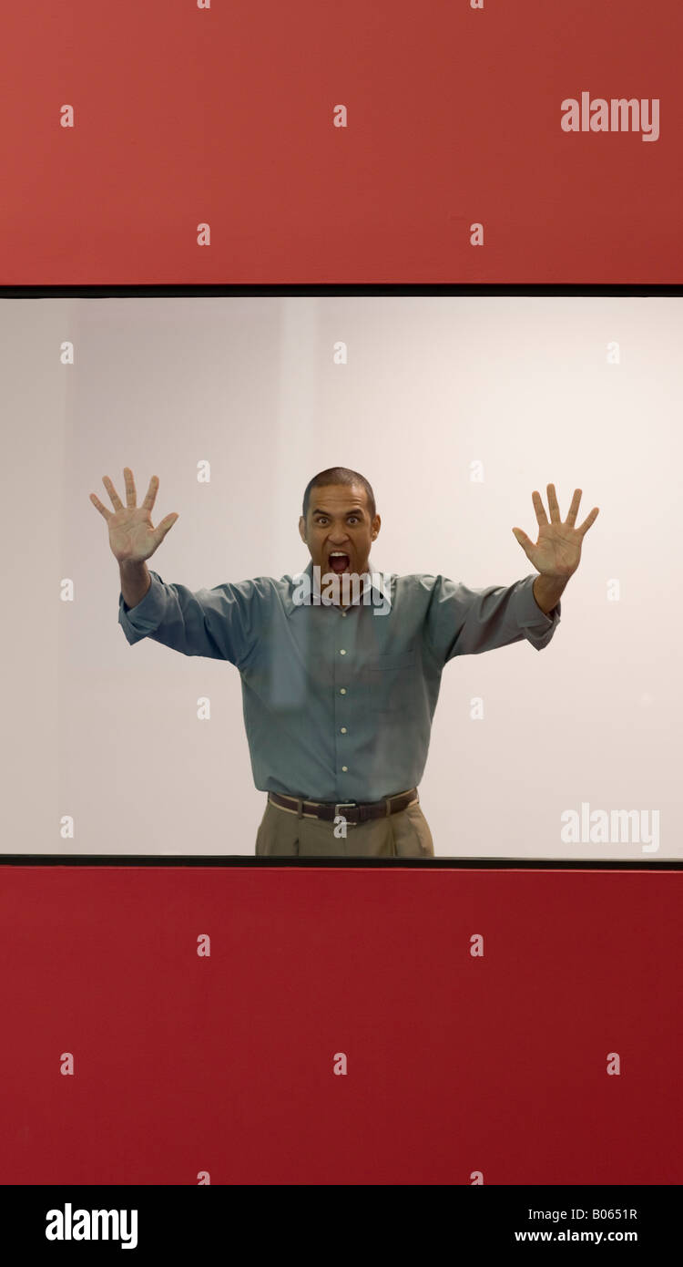 Imprenditore urlando dietro la finestra di ufficio Foto Stock