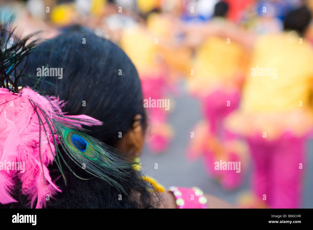 Un messicano di testa di donna con una piuma PEACOKS su i suoi capelli, partecipando al carnevale locale a guardare la gente ballare Foto Stock