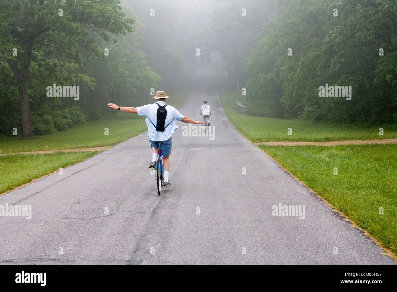 Due ciclisti viaggiare su strada di nebbia. Foto Stock