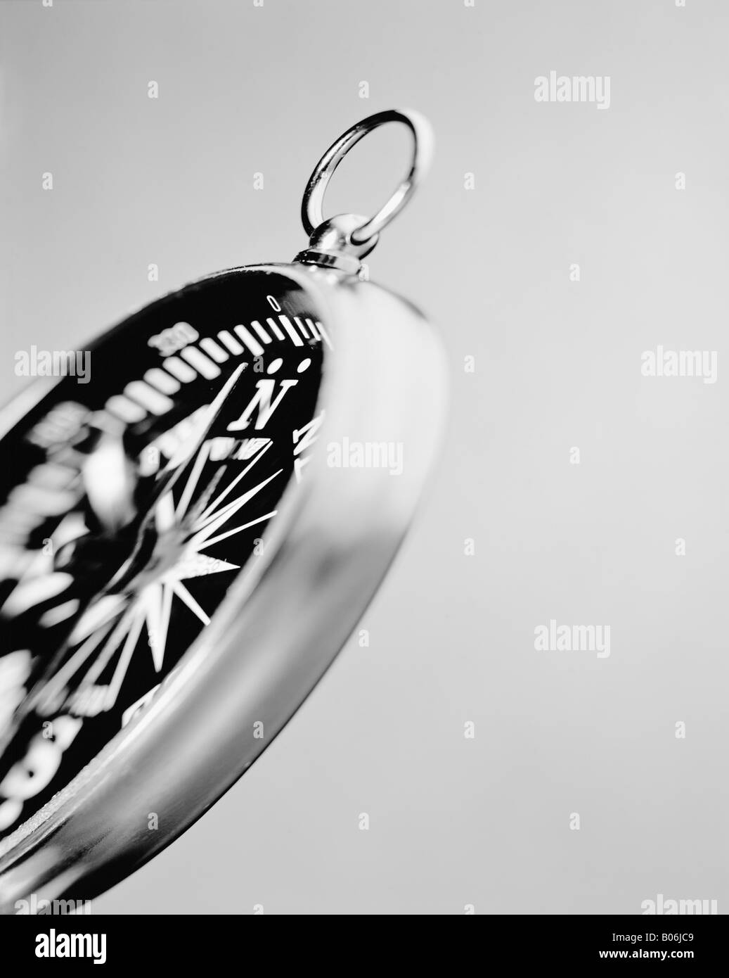 Immagine monocromatica di una bussola contro uno sfondo grigio Foto Stock