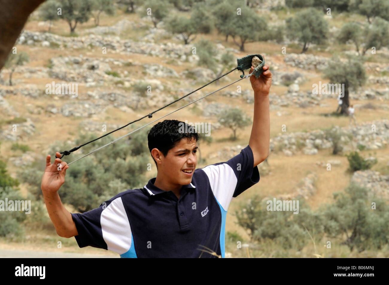 Un bambino palestinese un tiro sling shot durante una manifestazione di protesta contro il muro e occupazione nel villaggio di Bilin, Palestina. Foto Stock