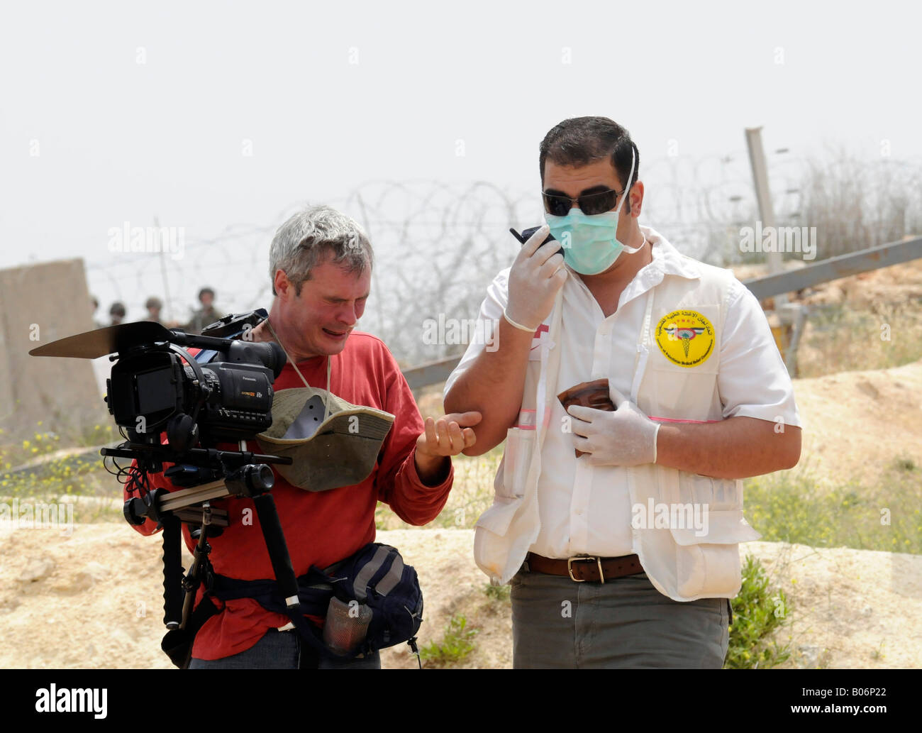 Un cameraman TV essendo aiutato dai palestinesi al personale medico durante una dimostrazione in cui gas lacrimogeni è stato utilizzato. Foto Stock