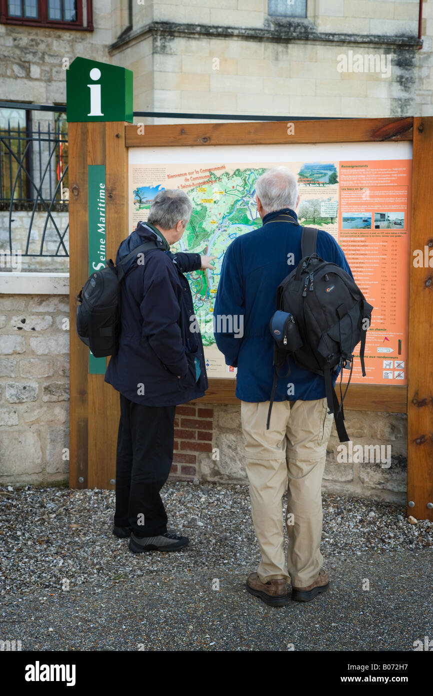 Due turisti Inglese guardando una mappa della città su una informazione turistica avviso fuori l'Abbaye de Jumieges. Foto Stock