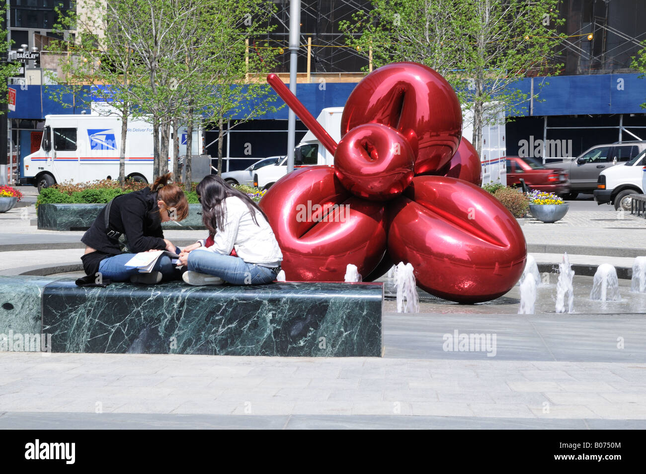 Due turisti puzzle su una mappa di Lower Manhattan accanto a Jeff Koons' scultura "Balloon Flower (rosso)" 7 World Trade Center. Foto Stock