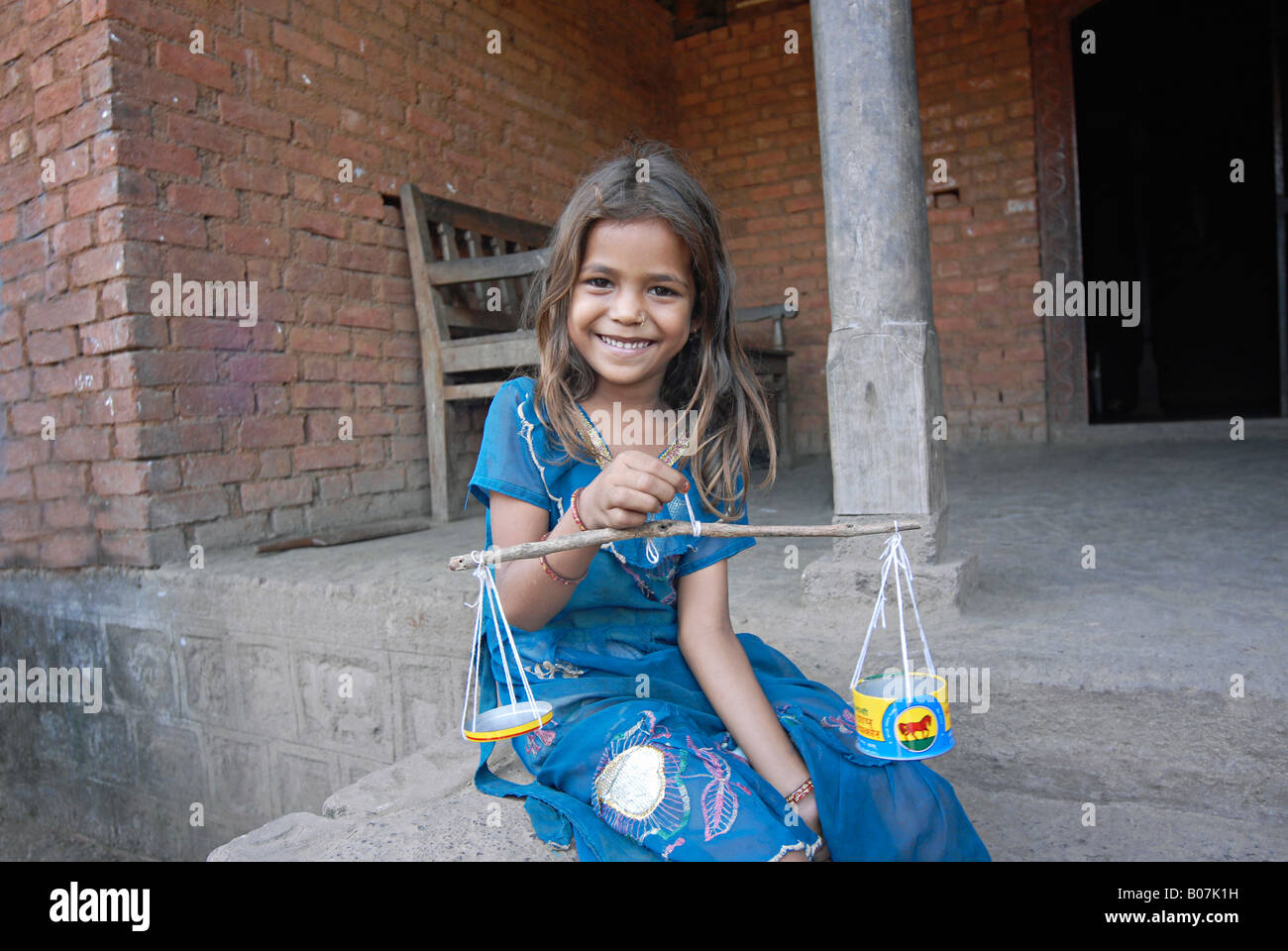 Un Malhar Koli tribù ragazza che gioca con fatti a mano uno strumento di misurazione. Foto Stock