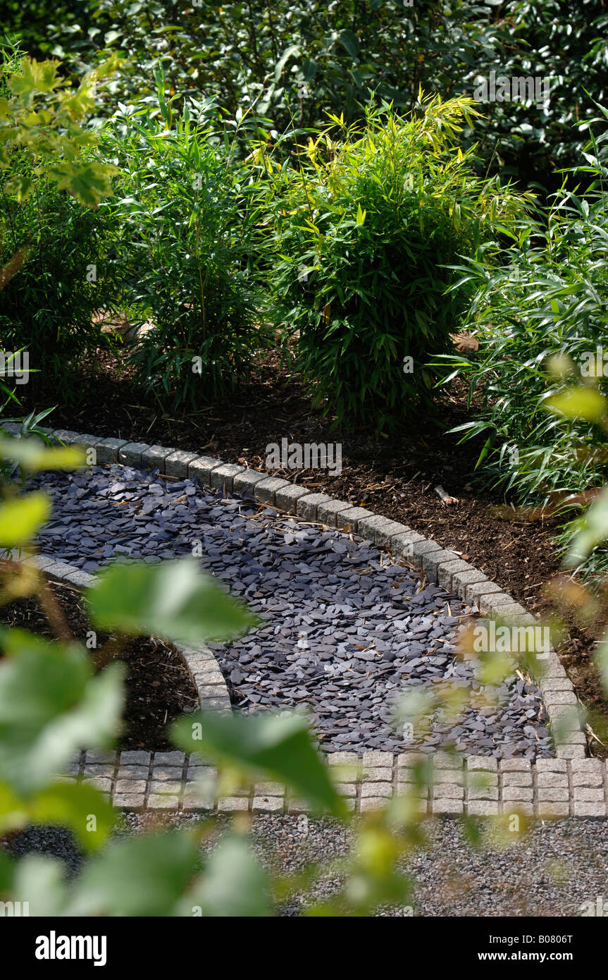 Un percorso posati con frammenti di ardesia e bordato con ciottoli di granito Foto Stock