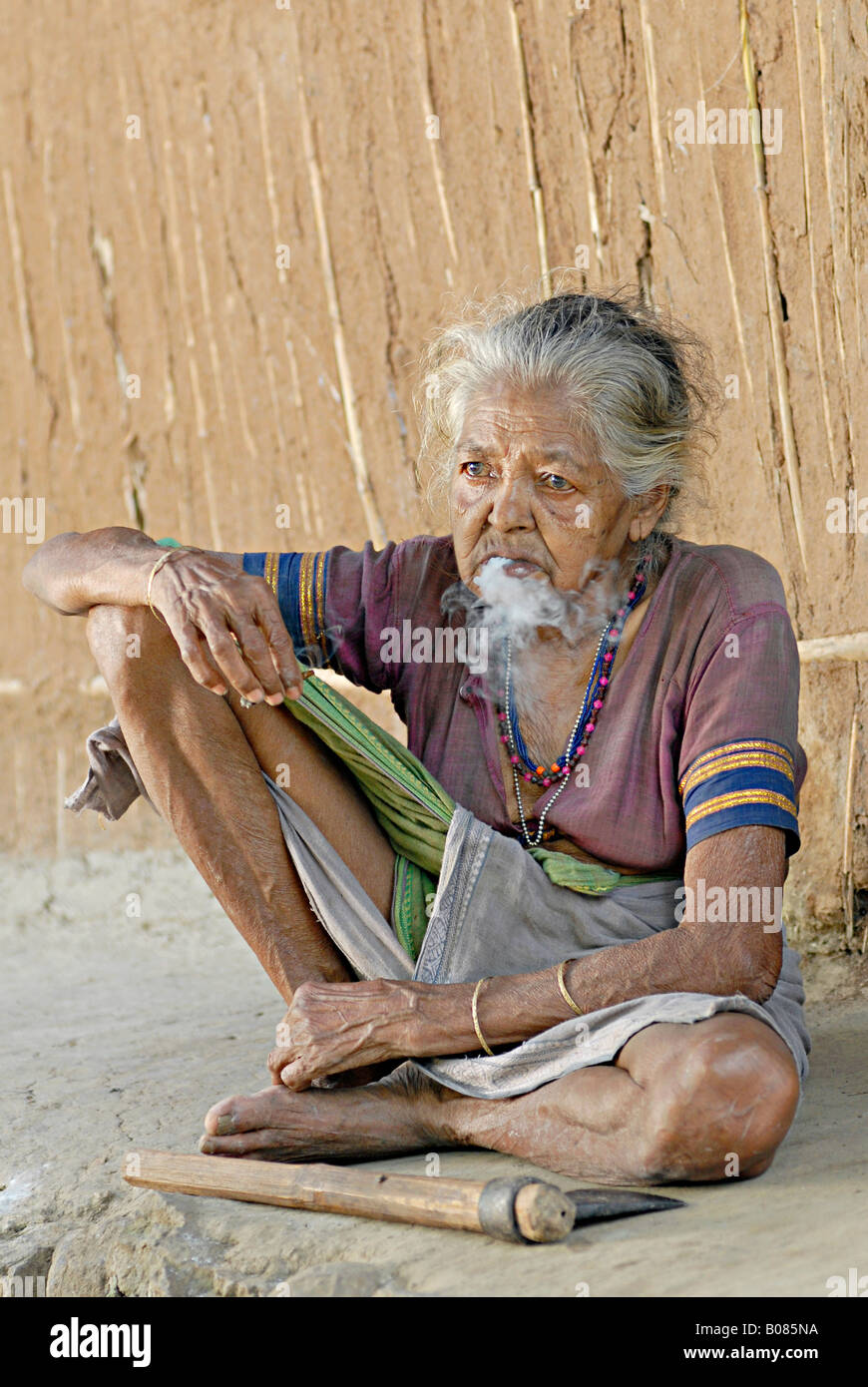 Vecchia donna fumatori bidi, un indiano a mano fatte di sigarette di tabacco o beedi foglie. Warli tribe Foto Stock