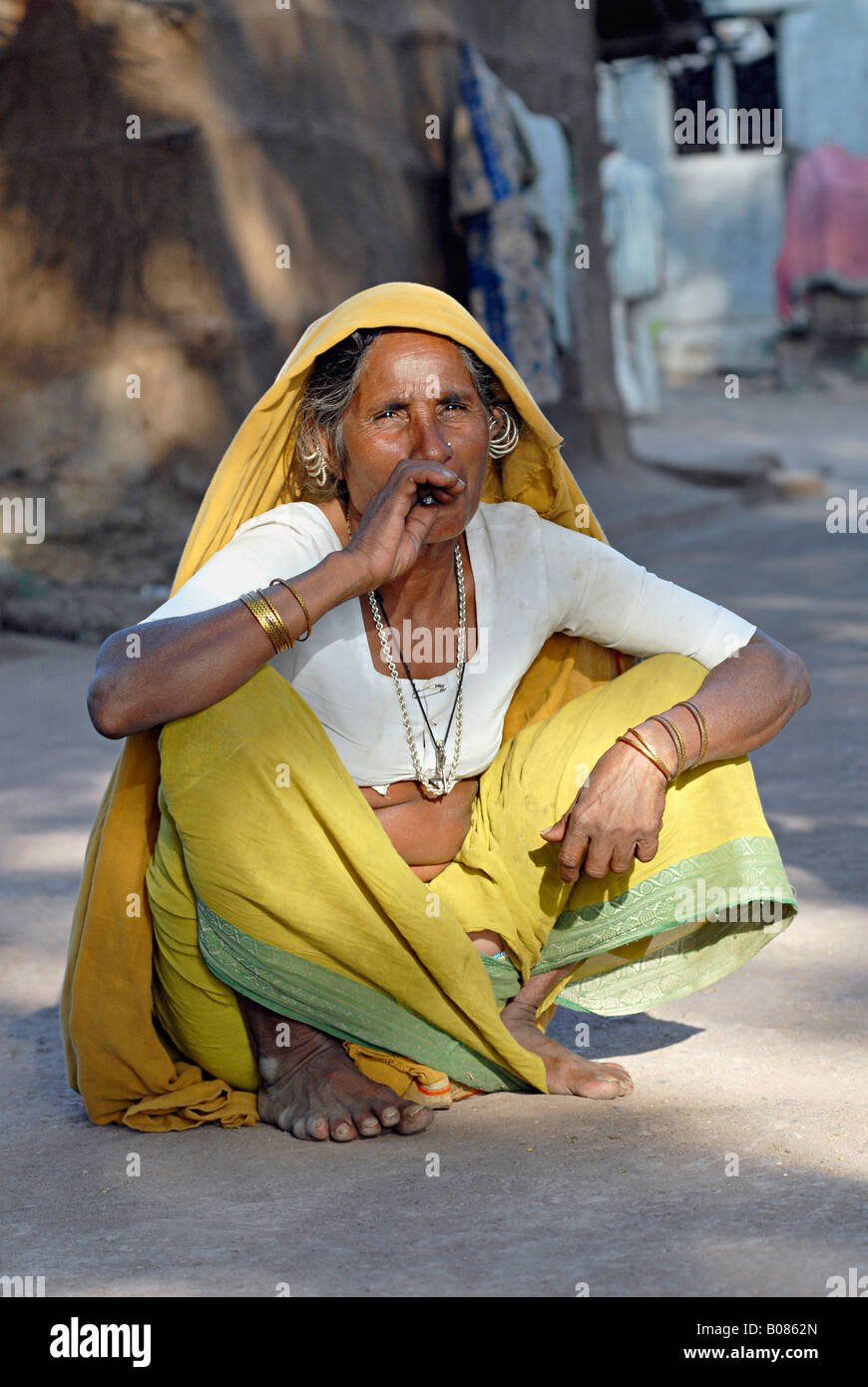 Il vecchio donna tribale fumatori bidi, un indiano a mano fatte di sigarette di tabacco o beedi foglie. Tribù Bhil Foto Stock