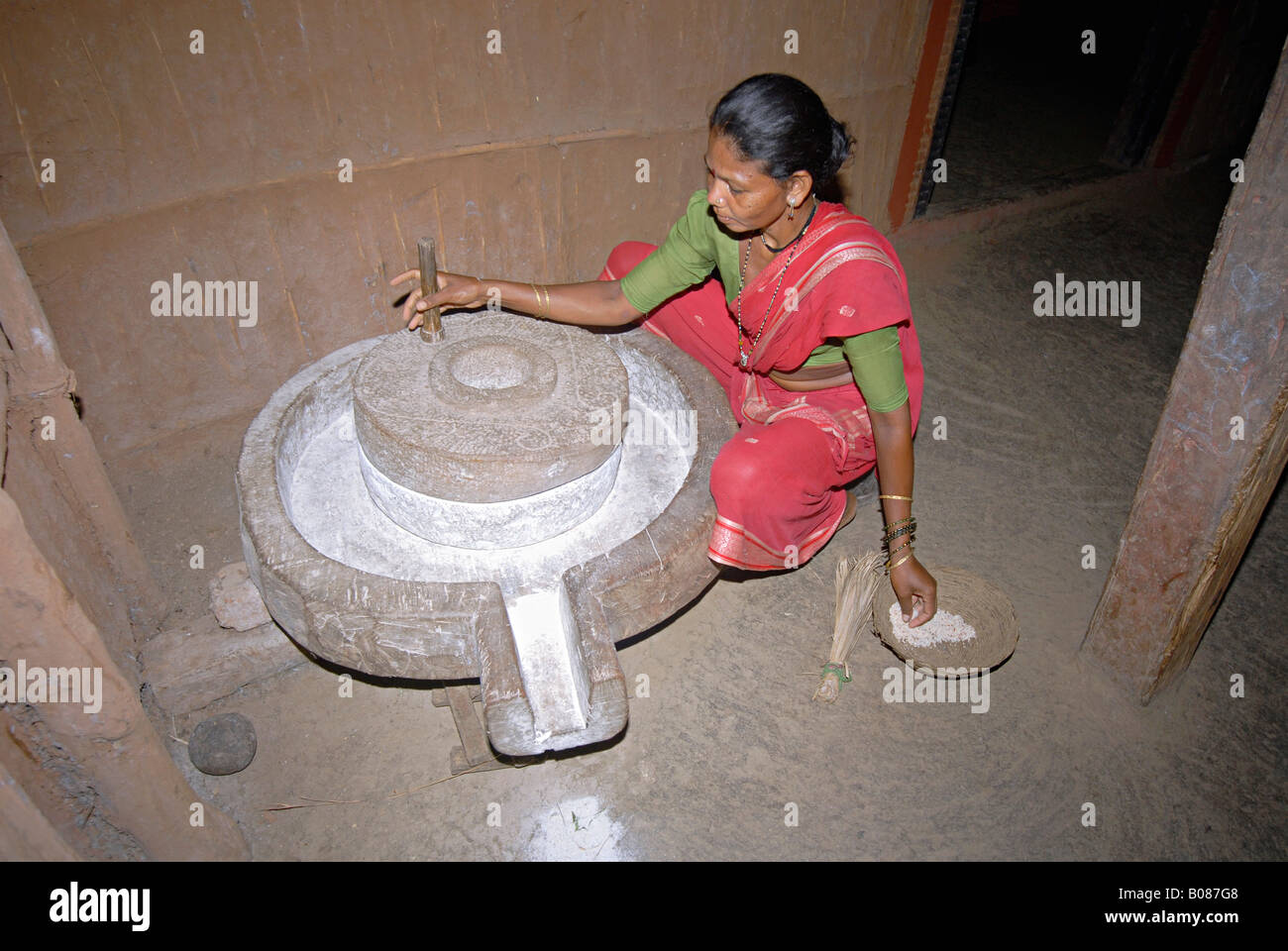 Warli donne tribali macinazione di riso. Foto Stock