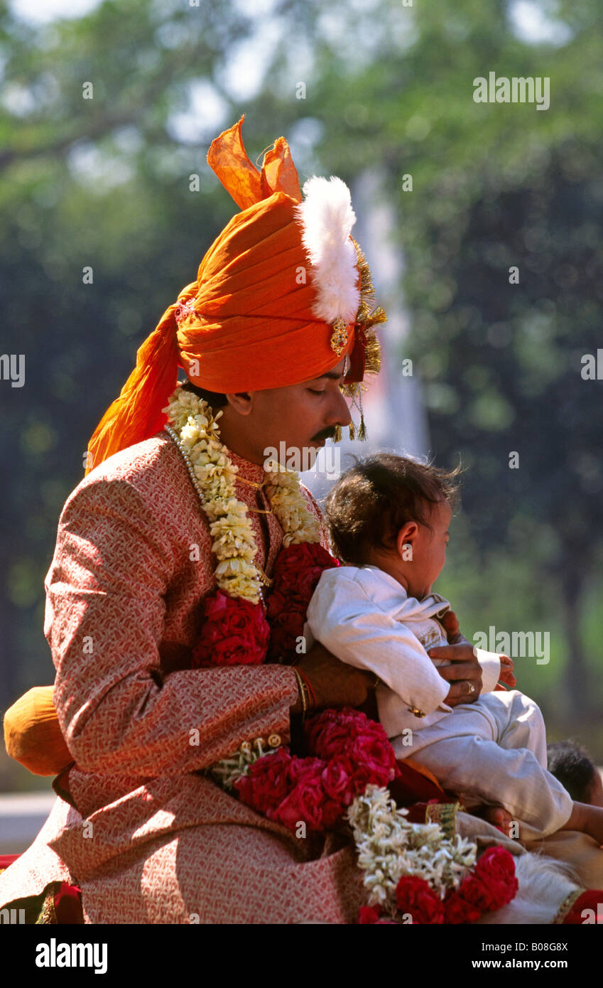 India Ahmedabad Gujerat corteo nuziale lo sposo a cavallo con il bambino in strada Foto Stock