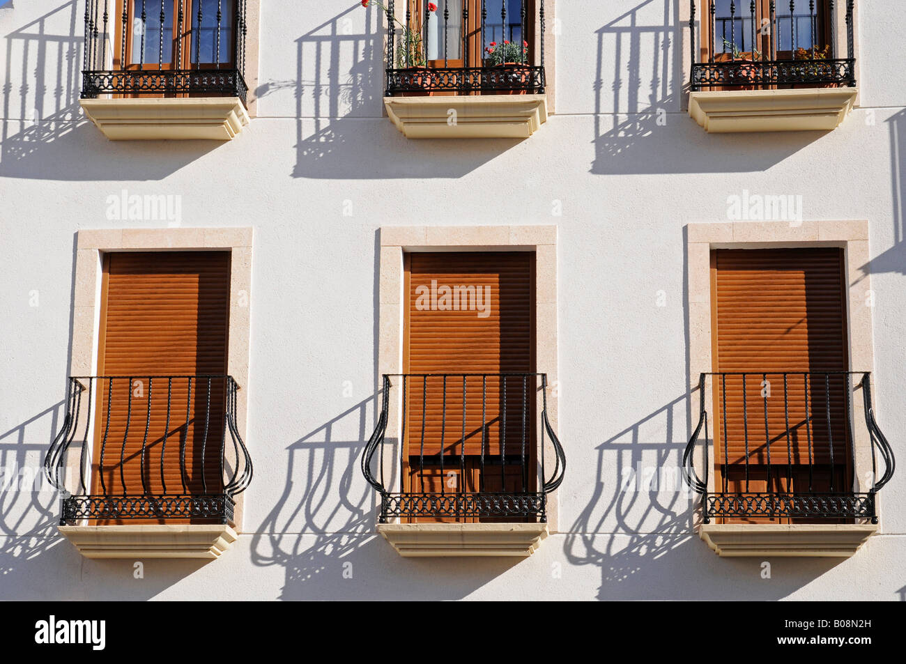 Windows con open e persiane chiuse dietro di ringhiere in ferro battuto su  una facciata di edificio nel centro storico di La Nucia, Ali Foto stock -  Alamy