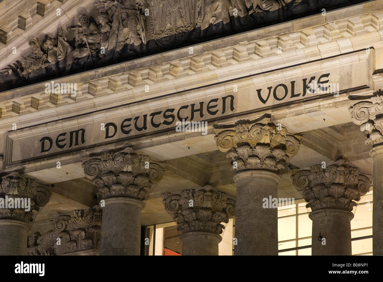 'Em Deutschen Volke' ('per il popolo tedesco") inscritto sopra l ingresso del Reichstag (parlamento tedesco) edificio da nig Foto Stock