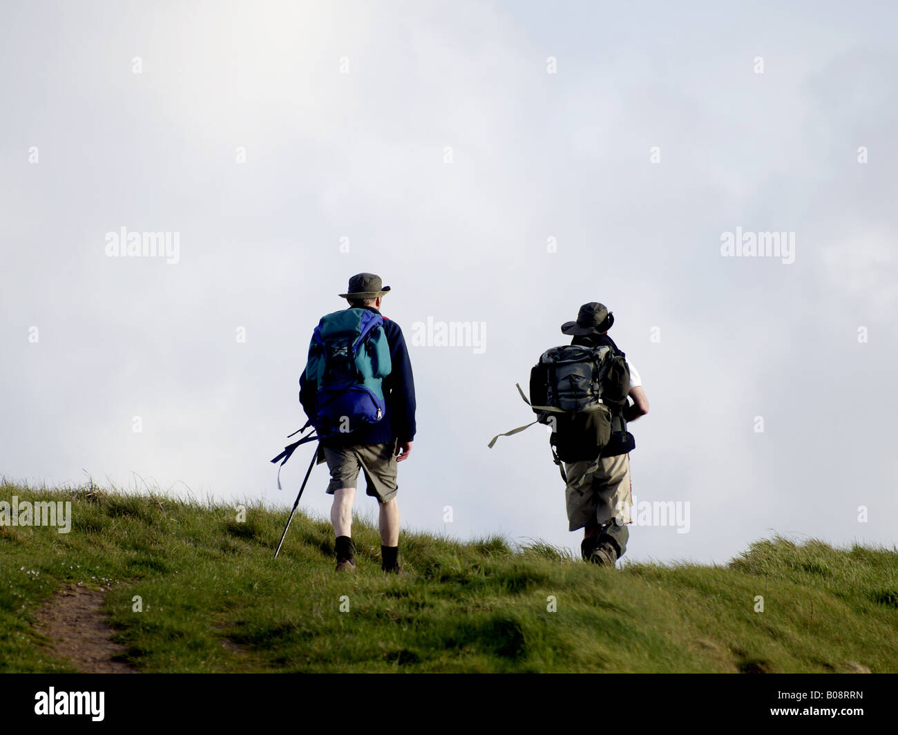 Due escursionisti cresta la cima di una collina Foto Stock
