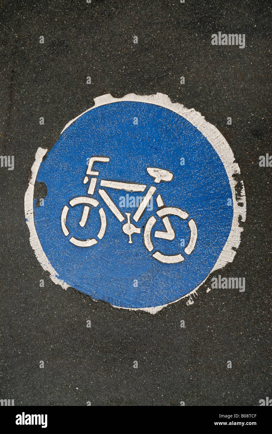 Usurati, weathered simbolo che indica un percorso per biciclette, dipinta sul marciapiede, asfalto Foto Stock