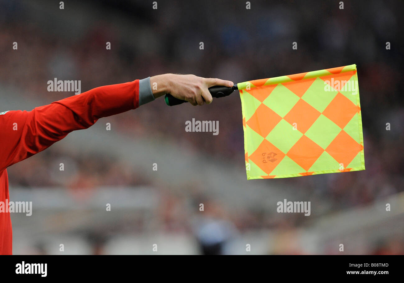 Assistente arbitro in una partita di calcio che mostra bandiera, posizione di fuorigioco Foto Stock