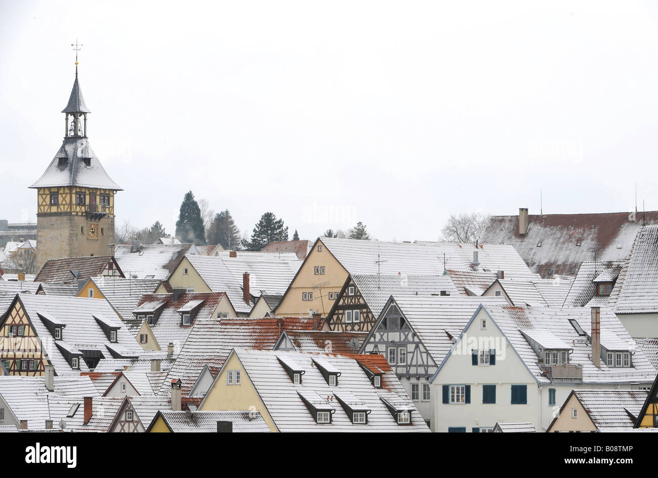 Vista su neve spolverato i tetti le case con la struttura in legno e la parte superiore della torre di Porta del centro storico di Marbach am Neckar, Baden-Wu Foto Stock