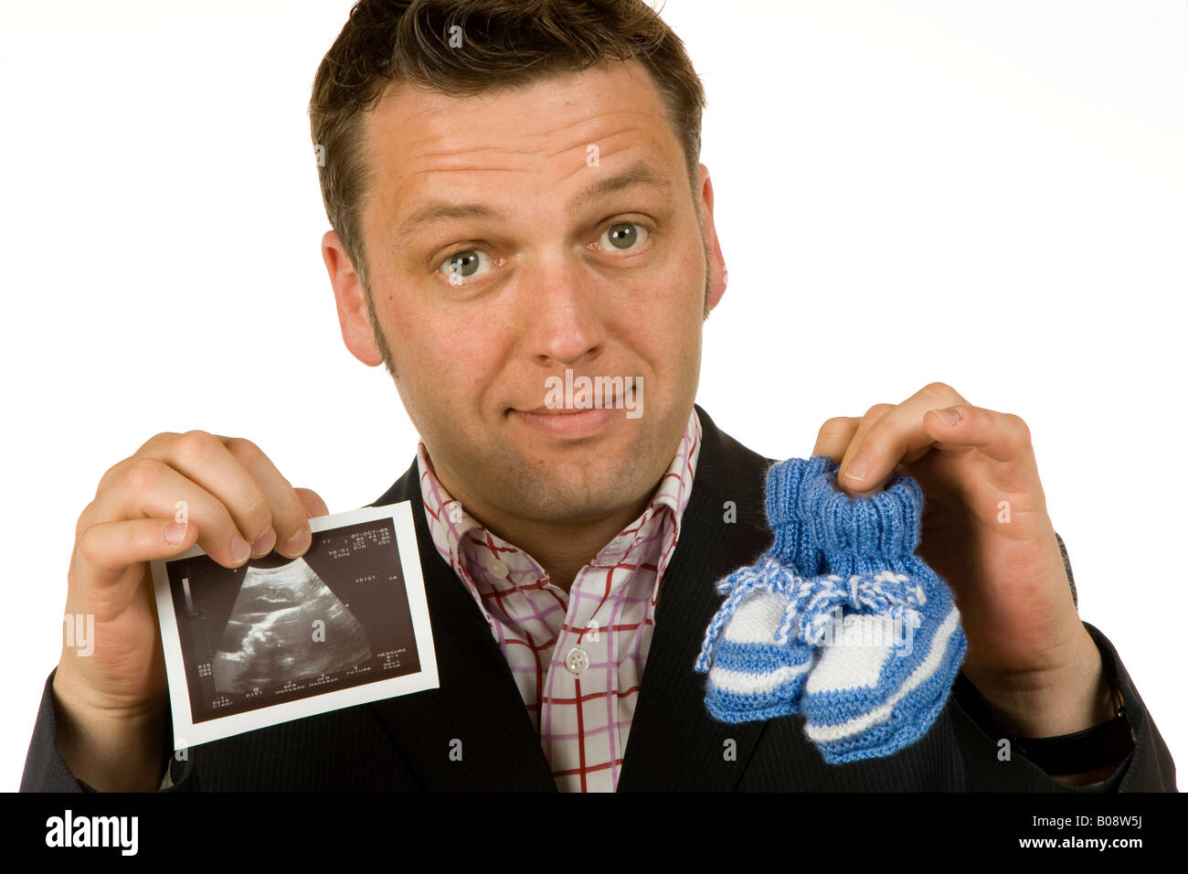 Il 40-anno-vecchio uomo d affari azienda scarpe per bambini e di una immagine ad ultrasuoni Foto Stock