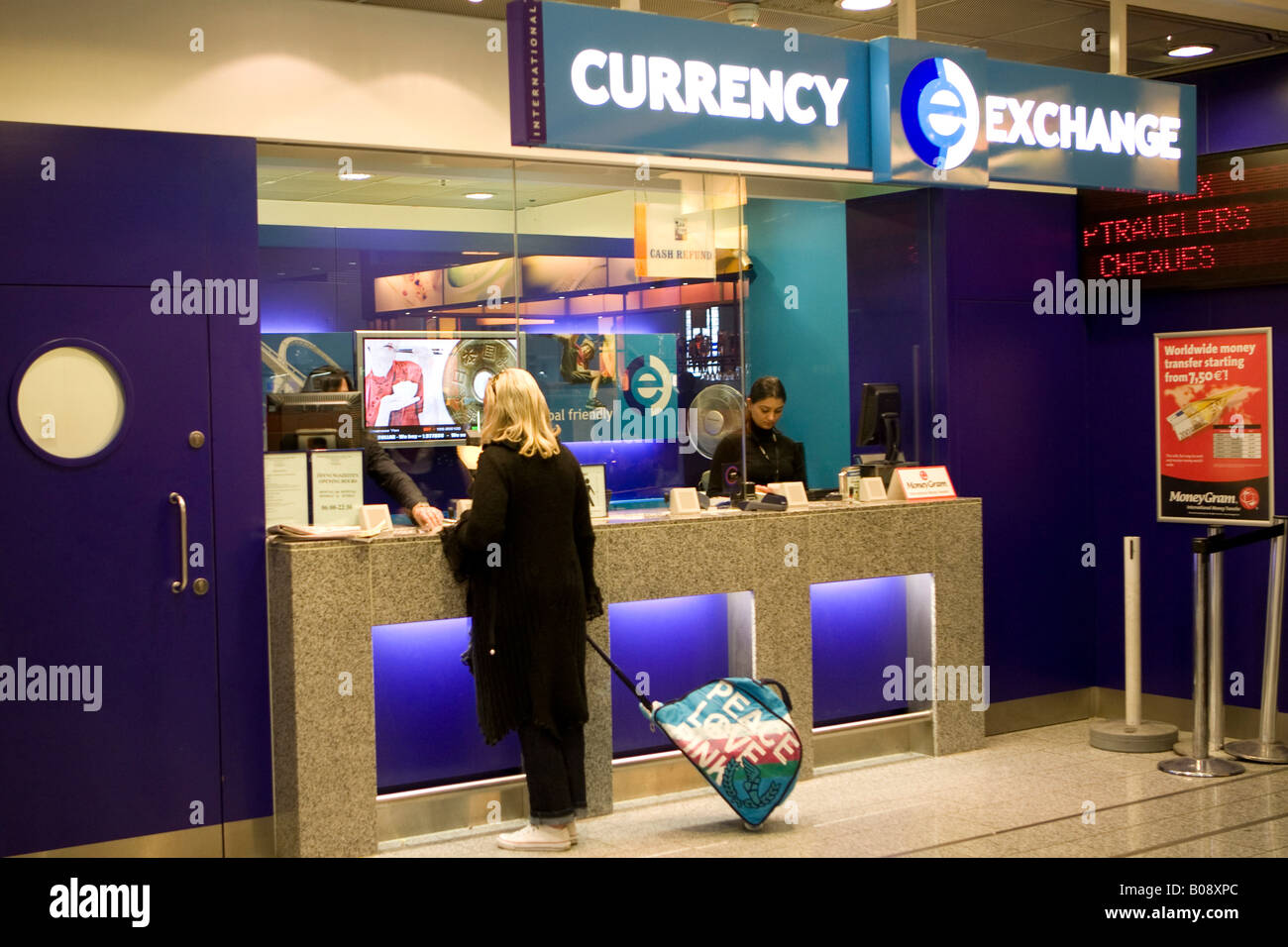 Giovane donna cambiare denaro presso uno sportello per il cambio valuta, l'Aeroporto Internazionale di Francoforte Hesse, Germania Foto Stock