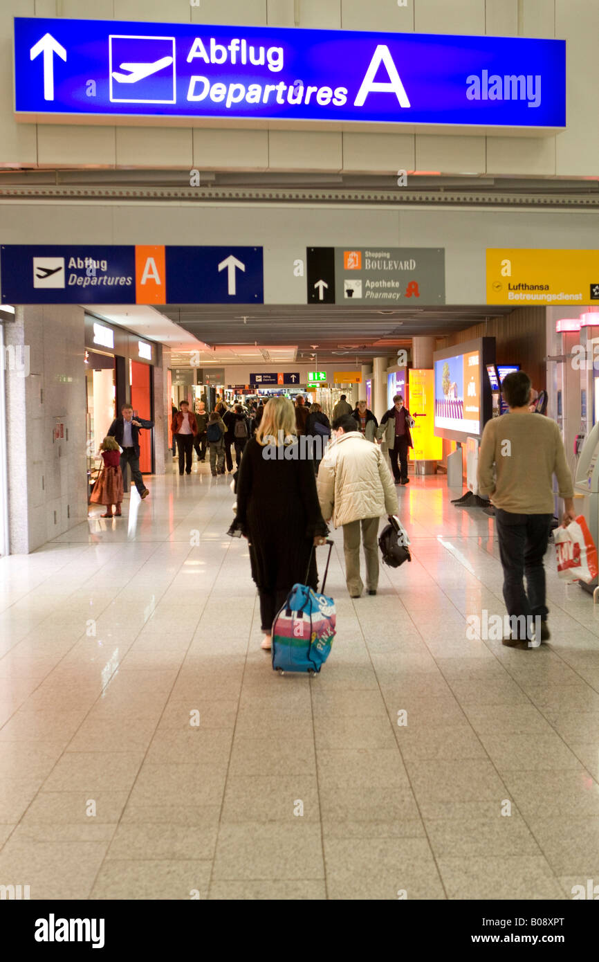 Il passeggero tirando il suo bagaglio a mano al suo gate di partenza, l'Aeroporto Internazionale di Francoforte Hesse, Germania Foto Stock