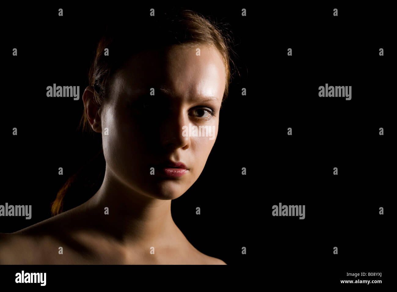 Ritratto di una giovane donna di forte illuminazione laterale, shadow Foto Stock