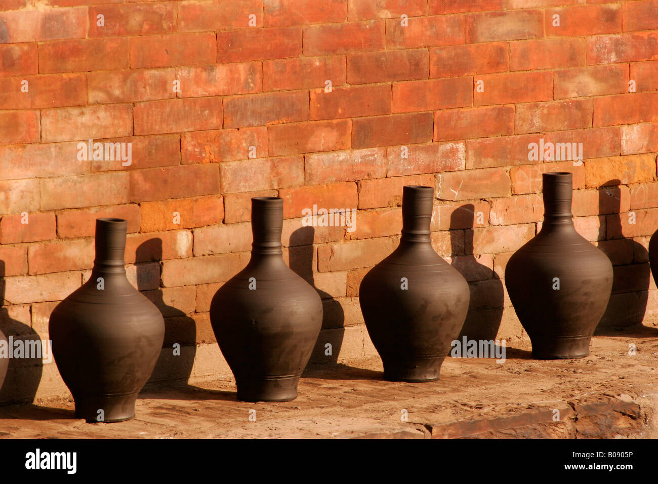 Vasi sul display in una piscina esterna in ceramica quadrata in Bhaktapur, Nepal Foto Stock