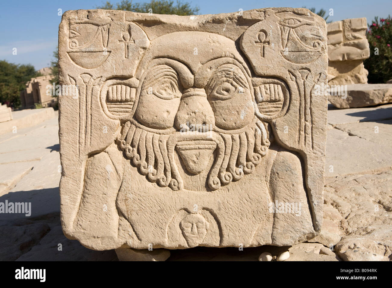 Un pezzo di colonna che mostra sollievo del dio Bes e il Tempio di Philae, Isola di Isis, Agilika, Aswan. Egitto Foto Stock