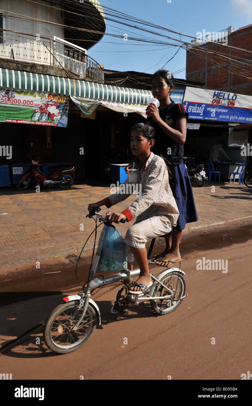 Bambini per le strade di Phnom Penh, il modo più rapido per ottenere intorno alla città, a cavallo di due su una bicicletta , phnom penh , Cambogia Foto Stock