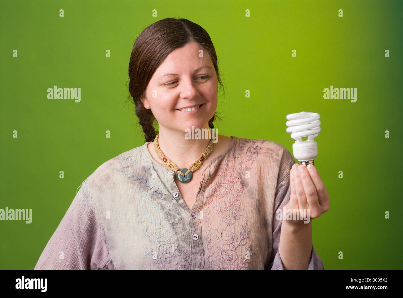 Un ambientalista detiene una lampada compatta a fluorescenza Foto Stock