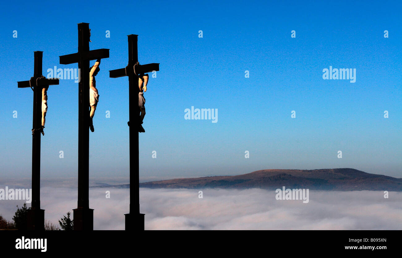 Tre crocifissi su una coltre di nebbia, Kreuzberg, Rhoen montagne, Baviera, Germania Foto Stock