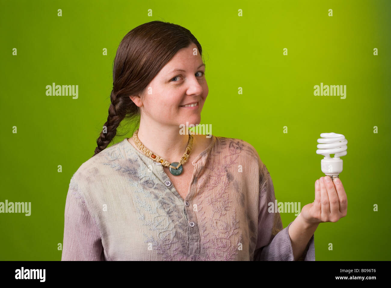 Un ambientalista detiene una lampada compatta a fluorescenza Foto Stock