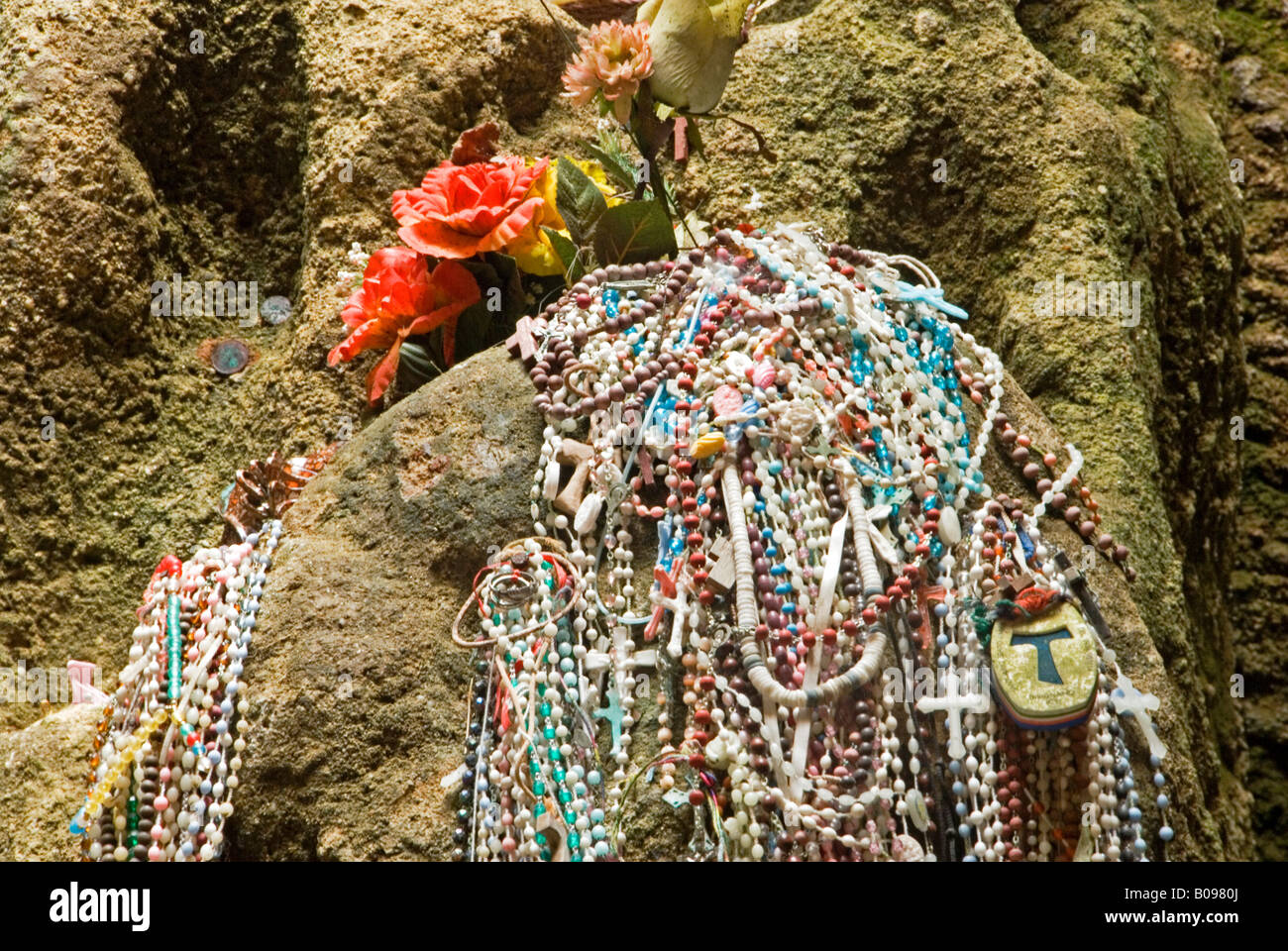 Rosari appeso al di sotto di fiori artificiali sulle pareti della grotta Chiesa di Piedigrotta, Pizzo, Calabria, Italia Meridionale Foto Stock