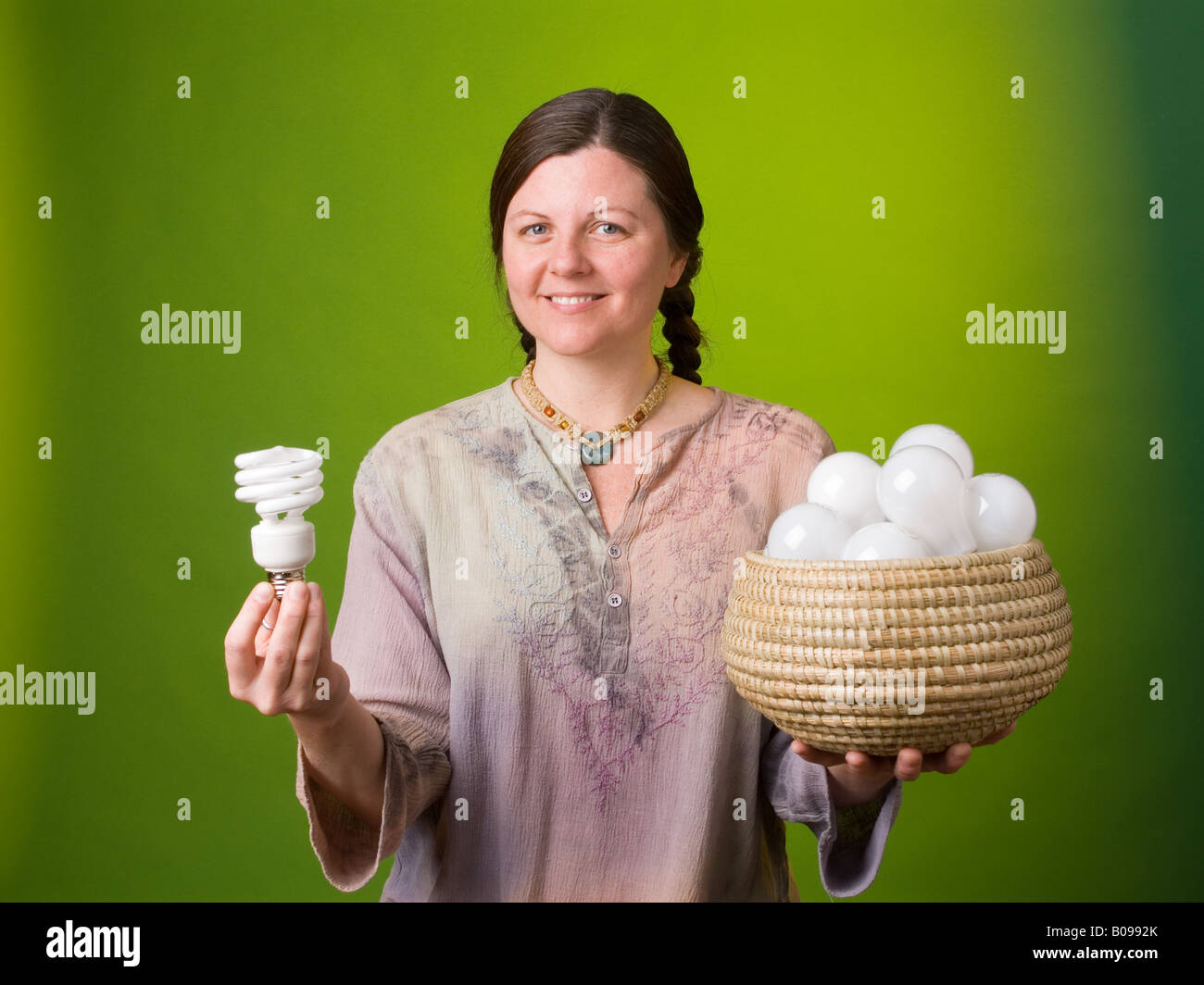 Un ambientalista confrontando una lampada compatta a fluorescenza per molte delle lampade a incandescenza Foto Stock