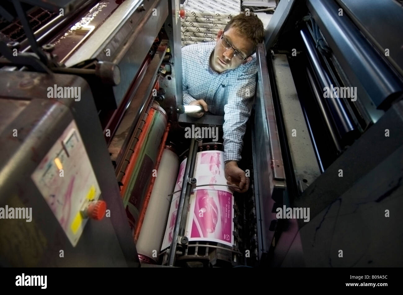 L'uomo la verifica di un litio macchina da stampa in un Kall Kwik shop rete in franchising di design, la stampa digitale e centri di copia Foto Stock