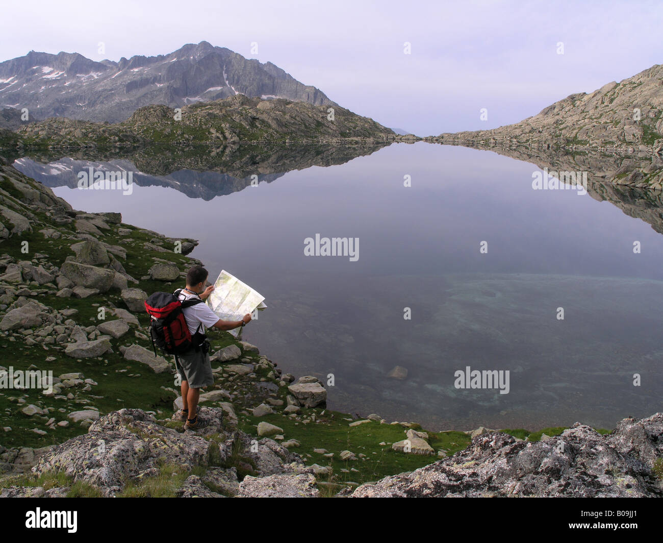 Gli escursionisti di montagna di fare trekking e la lettura mappa nel lago Travessani Aiguestortes Parco Nazionale Pirenei Lerida Catalogna Spagna Foto Stock