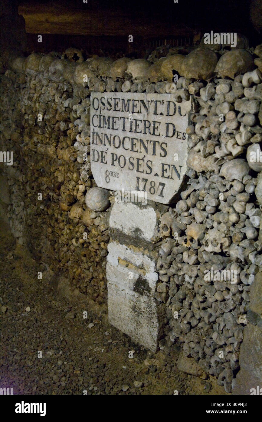 Teschi umani e ossa impilate in righe nelle catacombe sotterranee, Parigi, Francia. Foto Stock