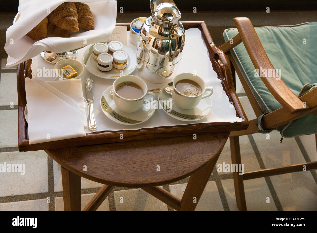 Tavolo per la colazione in un hotel con croissant e caffè due tazze riempite con nero caffè al mattino presto Foto Stock
