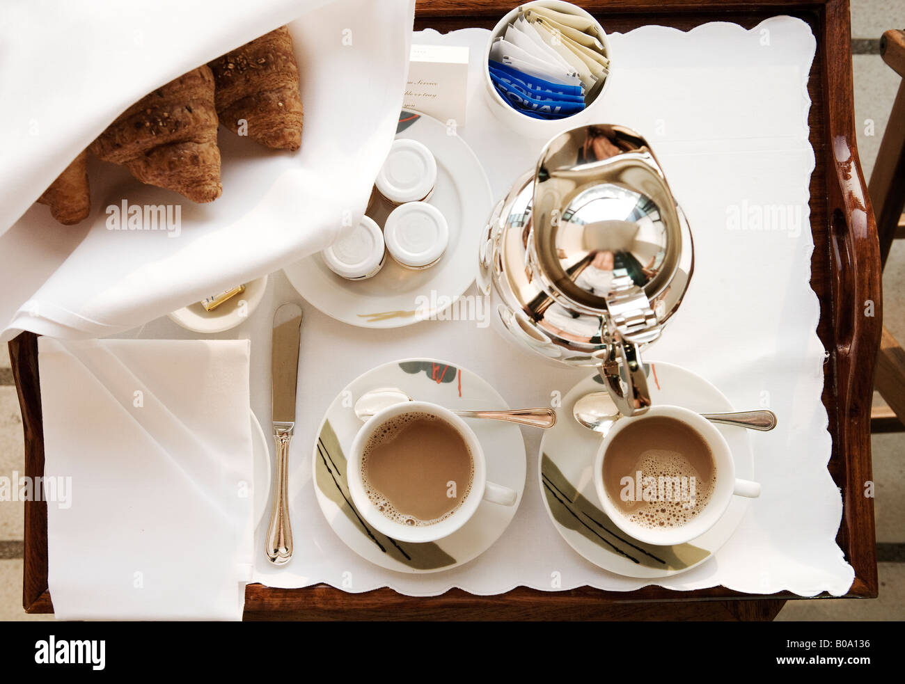 Tavolo per la colazione in un hotel con croissant e caffè due tazze riempite con nero caffè al mattino presto Foto Stock