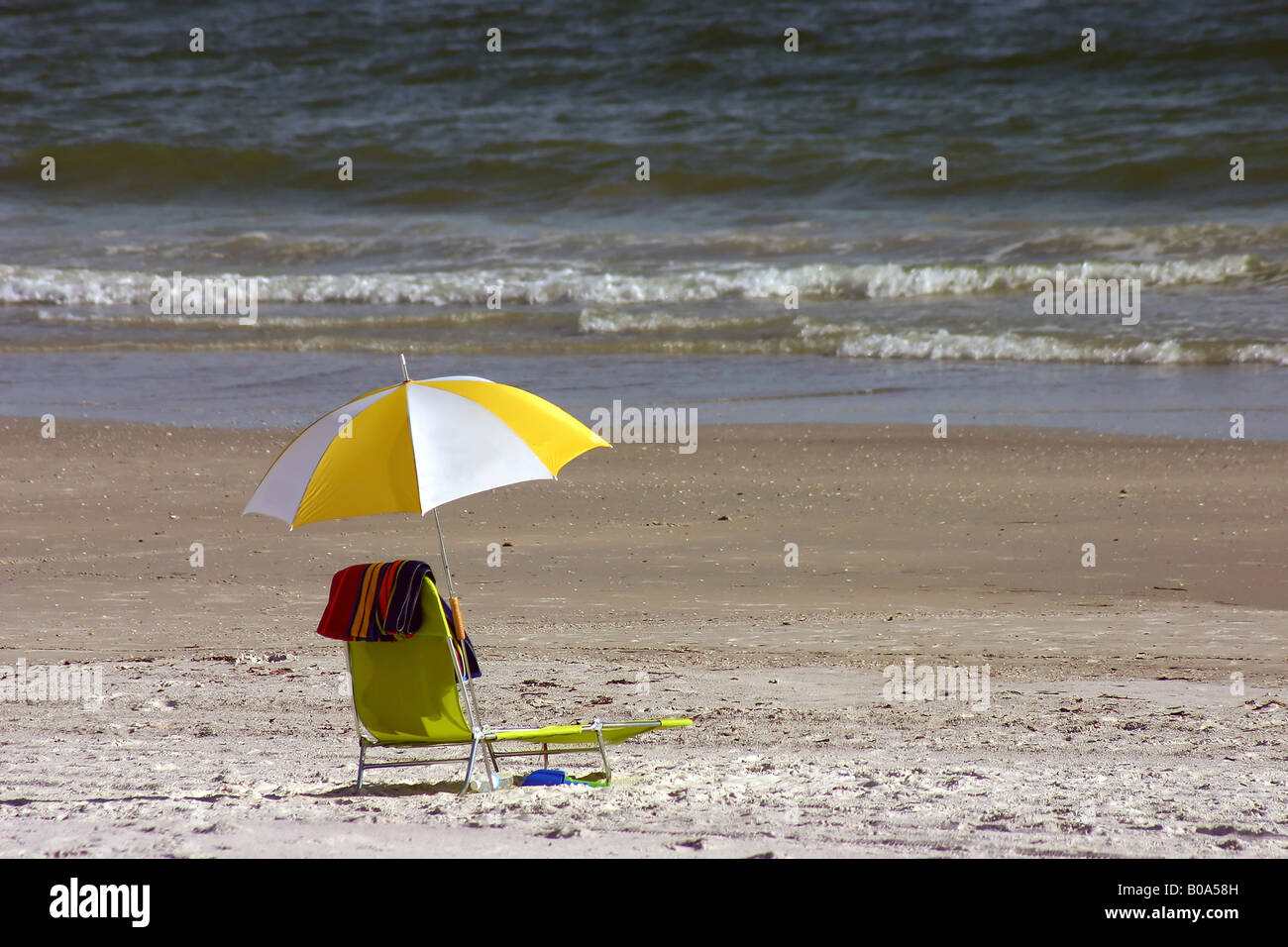 Sedia gialla con telo da spiaggia sulla costa del Golfo della Florida Foto Stock